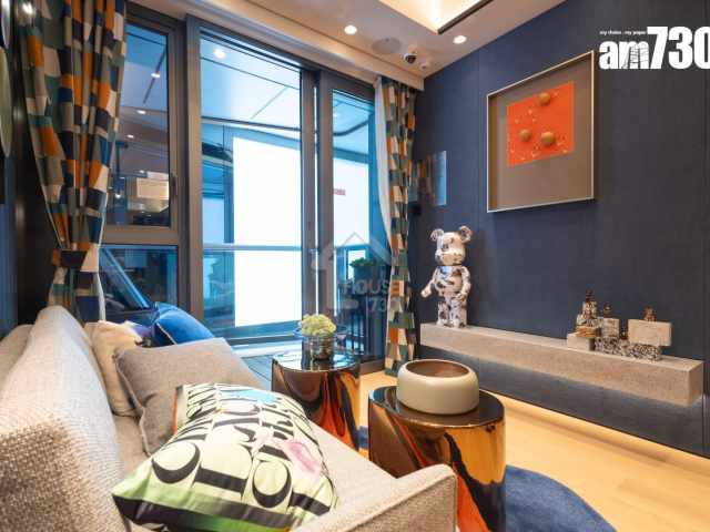 客廳以藍色波浪牆身配米色天花，中央擺放灰色調二人座梳化和簡約金色企燈，並以斑爛色彩組合的併格窗簾和地毯，營造出獨特的藝術氛圍。(資料圖片am730)